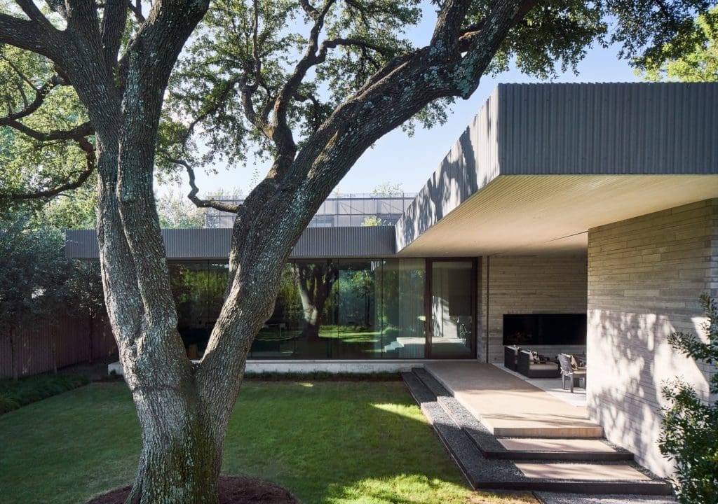 A covered outdoor kitchen and lounge area. The living room is seen through a wall of glass. (Photo by Stephen Karlisch)