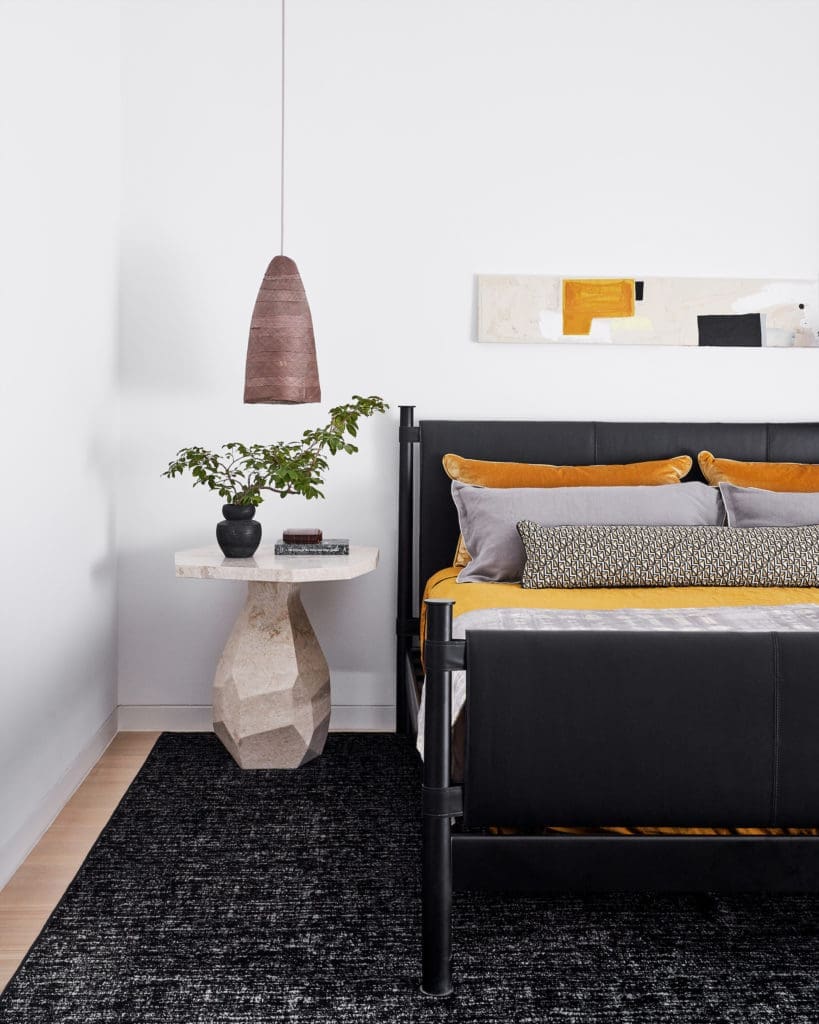 In a guest bedroom, Kara Mann for Baker
bed, straw pendant by Pinch Studio, Noir
marble table. Stark rug. Shams in Anthony George fabrics. Art by Amy Berlin Opsal. (Photo by Stephen Karlisch)