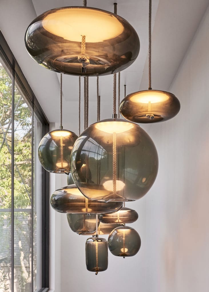 In the stairwell, smoked-glass pendants by Brokis are suspended by natural fibers. (Photo by Stephen Karlisch)