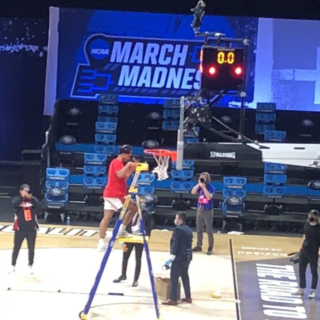 Quentin Grimes scales the ladder to cut down a piece of the net in Indianapolis. (Photo by Chris Baldwin)