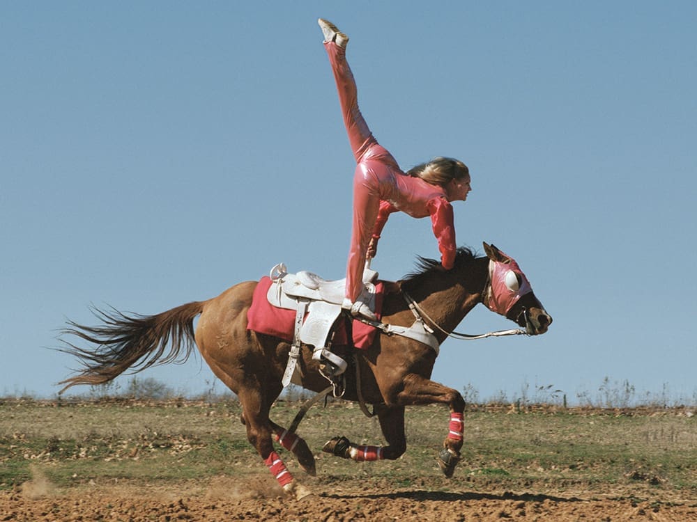 Laura Wilson's "Nikki Cammaert, Trick Rider, Weatherford, Texas (Balancing on horse)," 2001, at Red & White Gallery.
