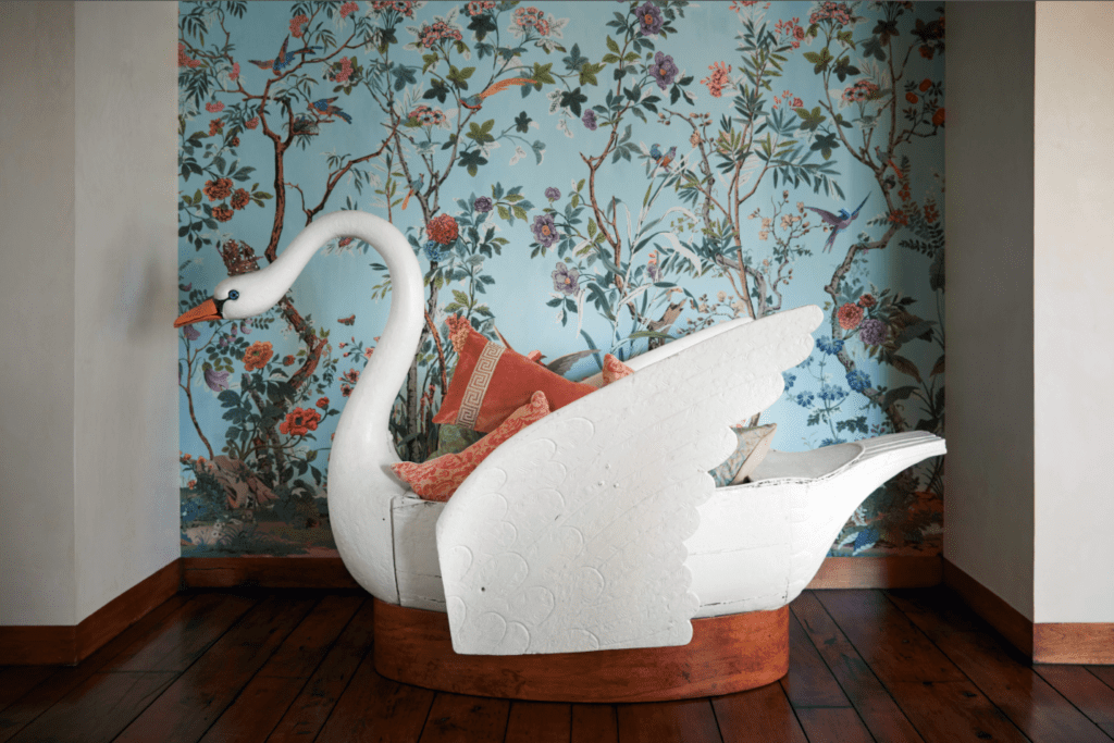 The 18th-century swan rowboat, displayed like a piece of sculpture and filled with Fortuny pillows, once belonged to the children of a noble French family and was kept on their pond in southern France. Zuber hand-painted wallpaper. (Photo by Pär Bengtsson)