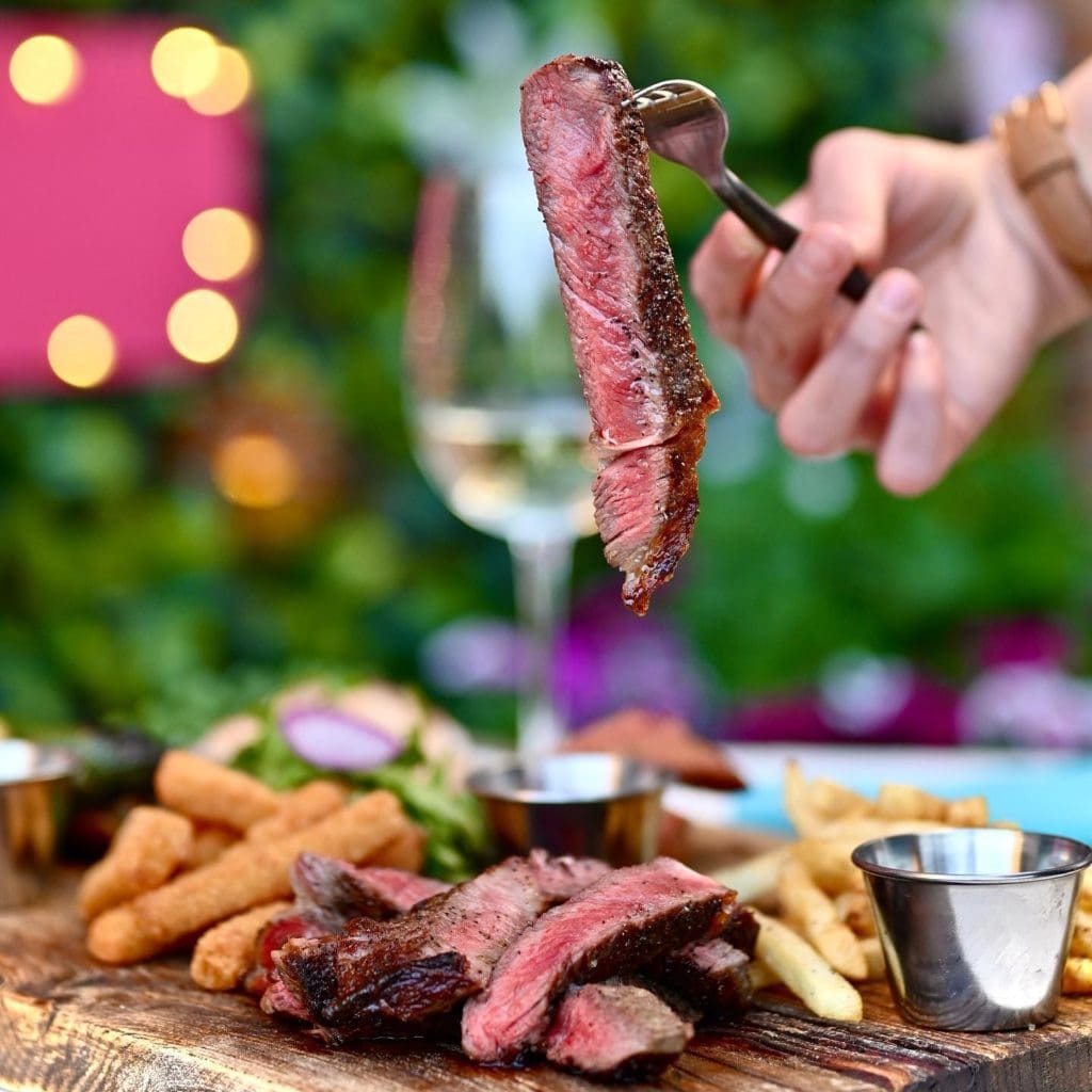 Amanda's Board comes with rib eye steak, pork loin, jalapeno sausage, Yuca fries, French fries, and green salad. (Courtesy of Ocho)