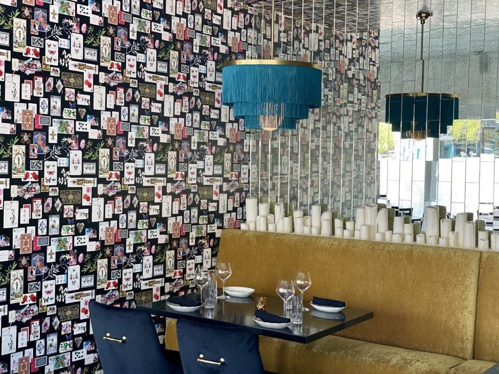 Âme's decor includes velvet gold couches and Christian LaCroix's Maison de Jeu wallpaper. (Photo by Kathy Tran)
