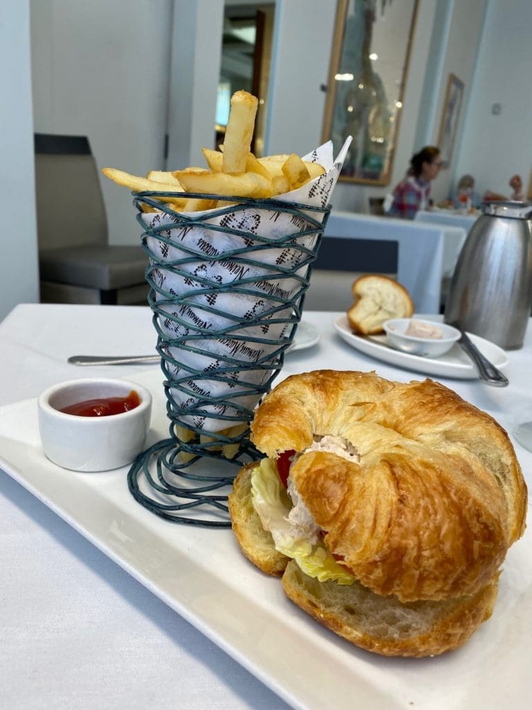 Chicken salad on croissant and house fries light up the pandemic-limited menu at Neiman Marcus' Mariposa cafe in Houston.