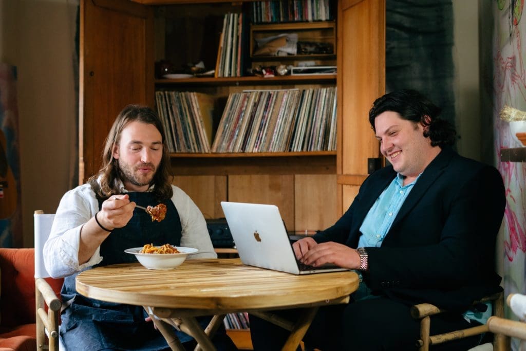 Thomas Stacy and Andrew Herron enjoy a bowl of pasta and Stacy's curated vinyl collection (photo by Yan).