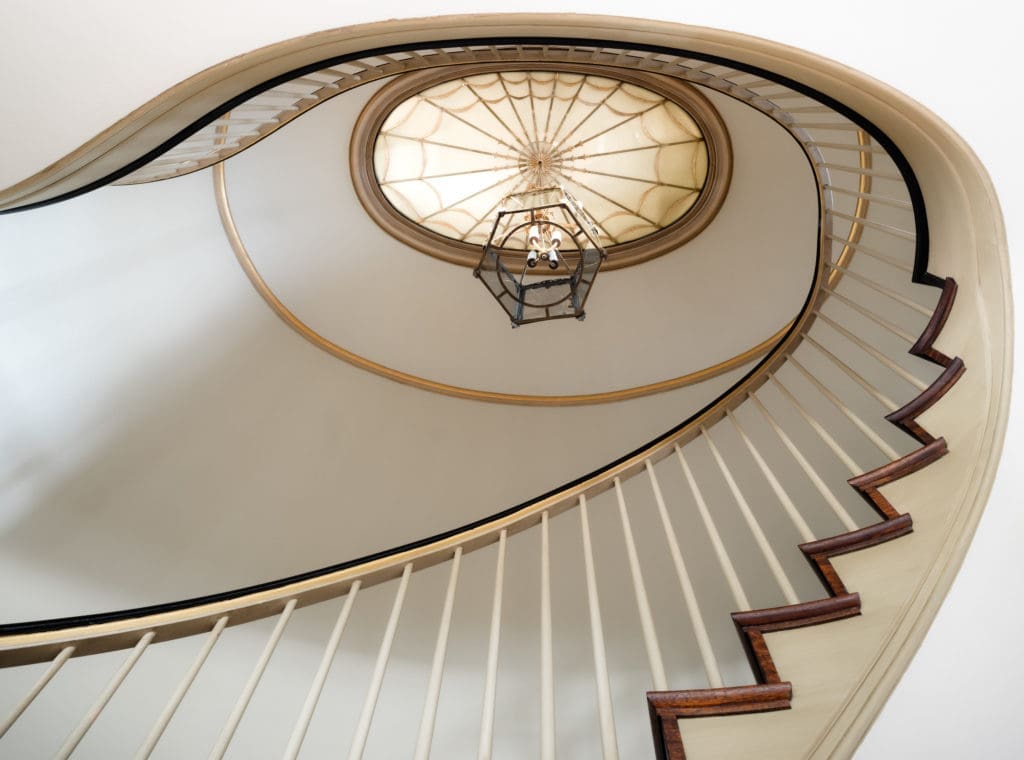 Serving as the crown of the dramatic two story foyer at 1317 North Boulevard, this large illuminated medallion with inlaid glass was imported from a Paris train station during the original 1920's build, paired elegantly with a 19th century chandelier. (Photo by Jonathan Calvert)