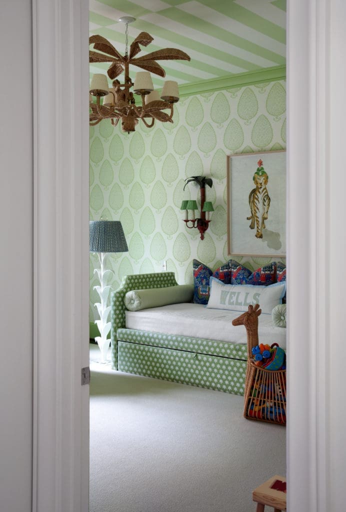 In the nursery, Katie Ridder wallpaper, Madre daybed and artwork, Mario Lopez Torres wicker light pendant. Vintage sconces. (Photo by Pär Bengtsson)