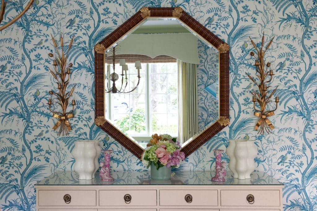 Grasscloth-covered buffet from Madre. Bunny Williams mirror. Antique sconces.  (Photo by Pär Bengtsson)