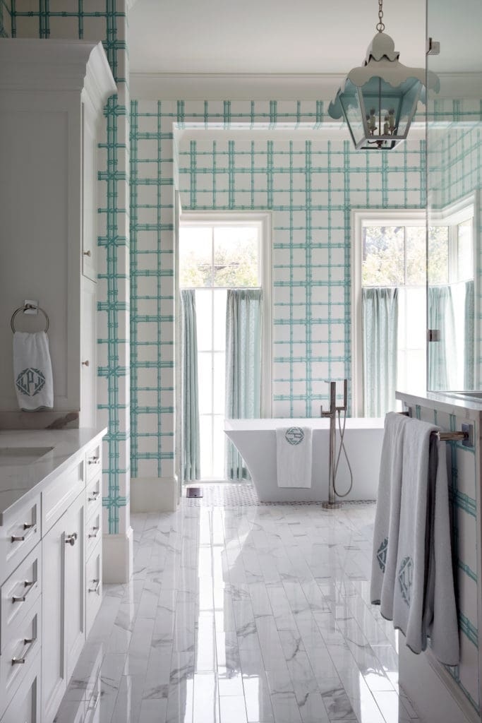 In the main bath, Meg Braff wallpaper is custom-colored to coordinate with Kravet bamboo fabric draperies. Coleen & Company lantern. Leontine Linens bath accessories. (Photo by Pär Bengtsson)