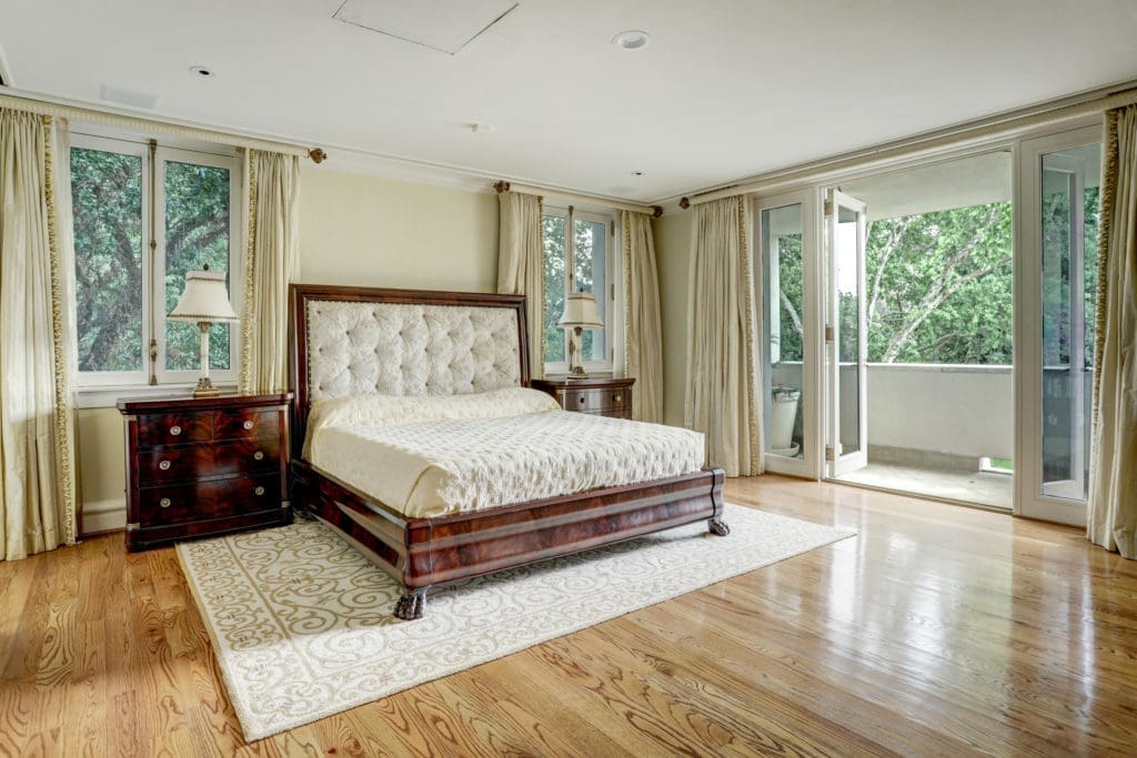 Behind the mirrored sitting room is the impeccable primary bedroom which features an abundance of natural light from a wall of French doors which lead to one of two covered balconies. (Photo by TK Images)