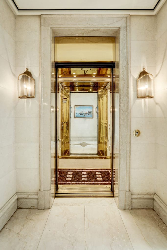 A recessed foyer for the functioning elevator at 1000 Kirby boasts double polished-brass elevator doors and is flanked by stunning French-style lanterns. (Photo by TK Images)
