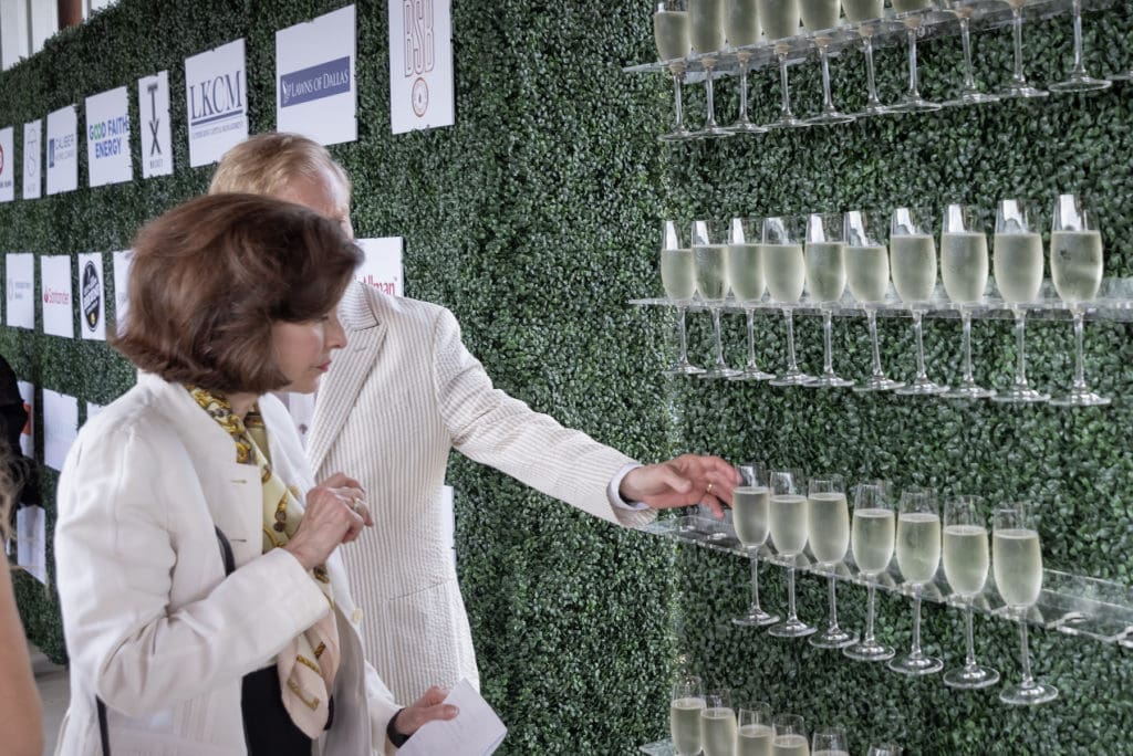 A wall of champagne flutes welcomed guests as they waited to take a photo with the Equest Mini Ambassadors.  (Photo by Thomas Garza)