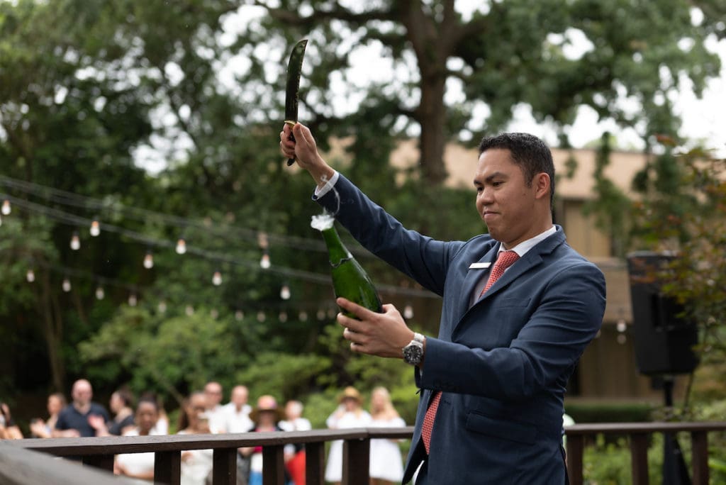The Houstonian sommelier Dat Le sabers a champagne bottle for Rosé & Roses rosé tasting and bunch at the private club. (Photo by Daniel Ortiz)