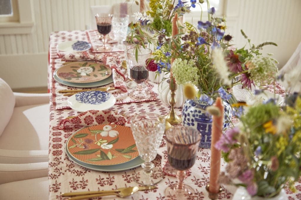 The table at Marcia Smart's Kitchenette Farm is set with Hunter Bell's Western Willow Red linens.