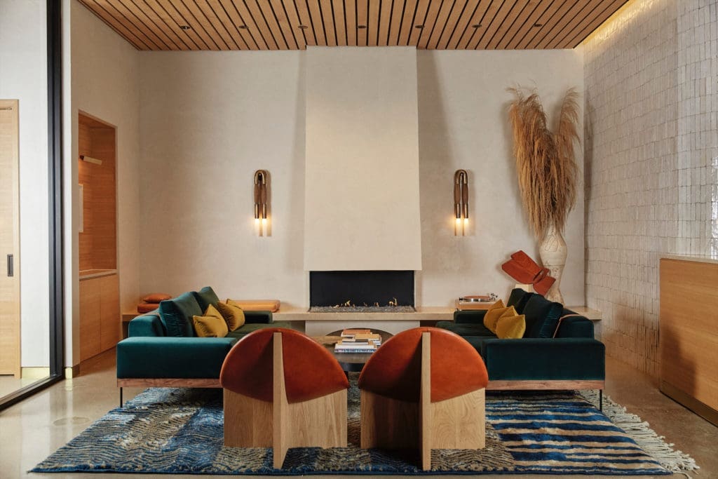 In the lobby, artisan- made sculptural chairs by Estudio Persona, L.A. Apparatus sconces. Custom Moroccan rug. Sofas from Croft House, L.A., in Kravet velvet. (Photo by Max Kutz)