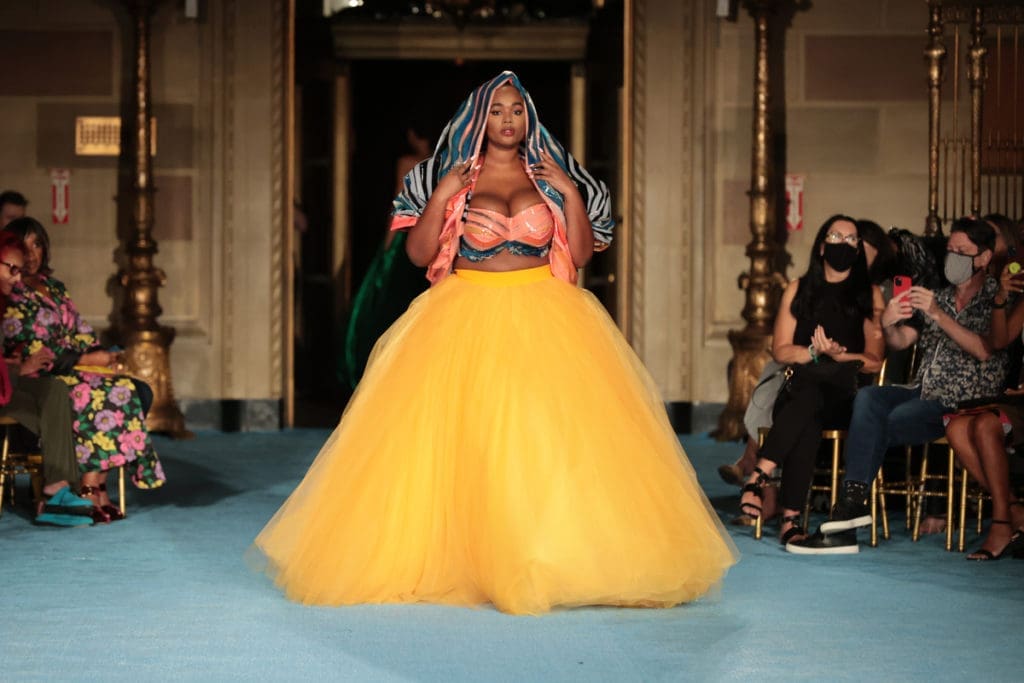 Model Precious Lee closed Christian Siriano's runway show in orange tulle skit, fitted bra and print headdress. (Photo by Mike Coppola/Getty Images for Christian Siriano)
