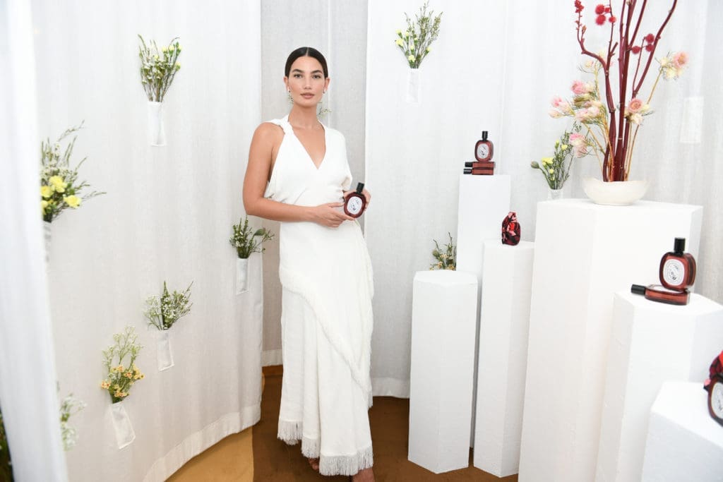 Model Lily Aldridge poses amid a floral area of the Diptyque pop-up show. (Photo courtesy of Diptyque)