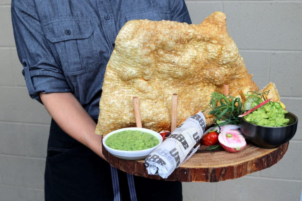 Chicharrones, a large fried pork rind is served as a starter with guacamole and salsa verde.  (Photo by Paula Murphy)