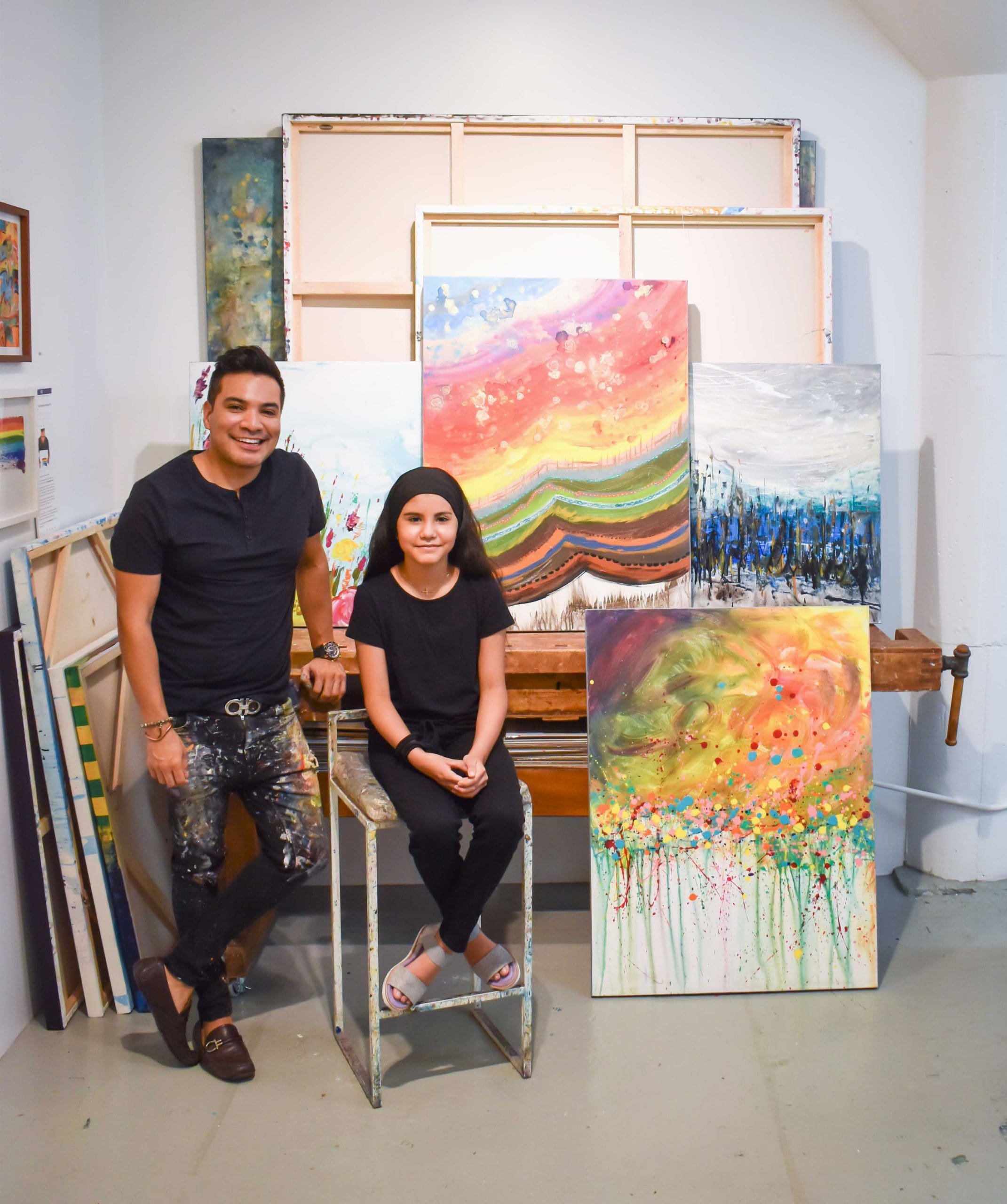 Melinda Moreno seated next to Edgar Medina and their opulent canvas, “Summer,” 2021.