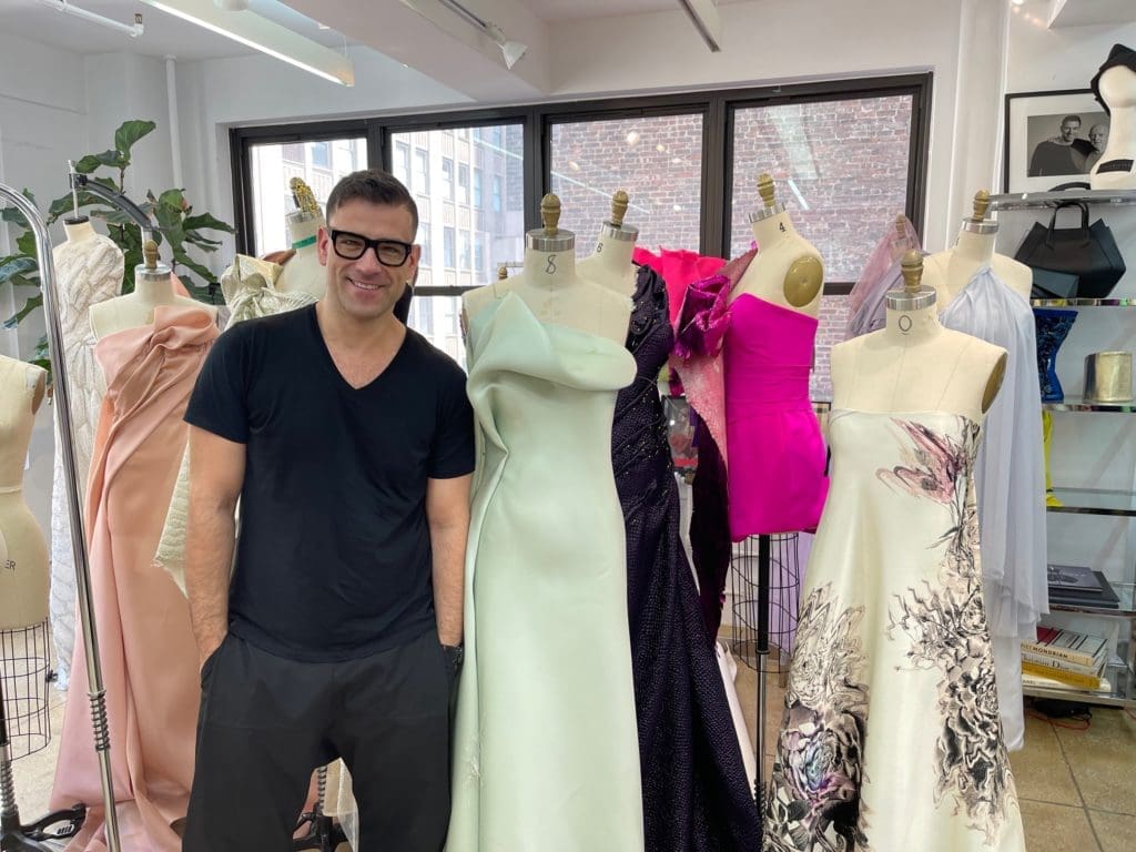 Rubin Singer poses in his New York studio amid some of his new glamour gowns. (Photo by Clfford Pugh)