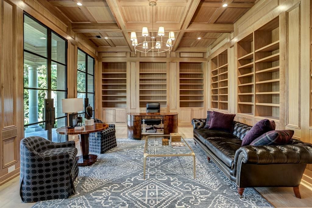 The study at 3001 Inwood with floor to ceiling white oak block paneling, box beamed ceiling, built in bookcases and cabinet storage, three sets of 10' steel and glass double doors to a covered terrace. (Photo by TK Images)