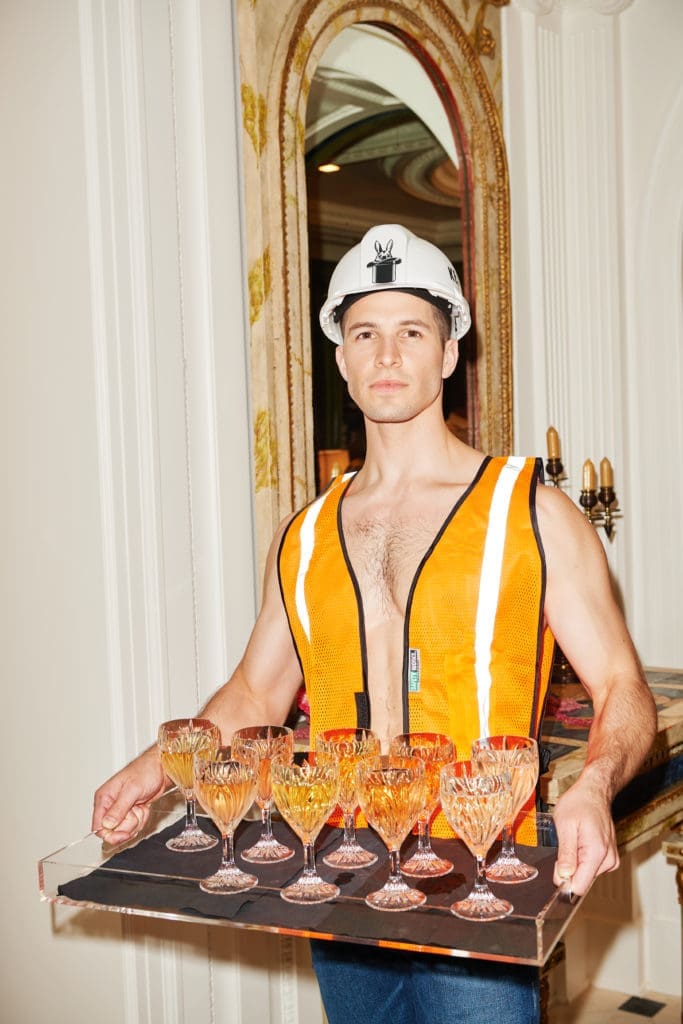A shirtless model citizen (David Friedrich) in a hard hat serving up cocktails. (Photo by Jonathan Zizzo)