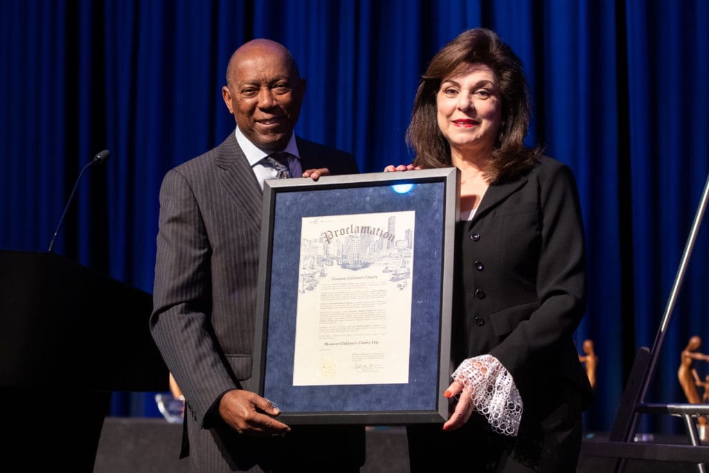 Mayor Sylvester Turner with Laura Ward declares it Houston Children's Charity Day in Houston on the occasion of the nonprofit's 25th anniversary luncheon, 2021 (Photo by Michelle Watson, catchlightgroup.com)