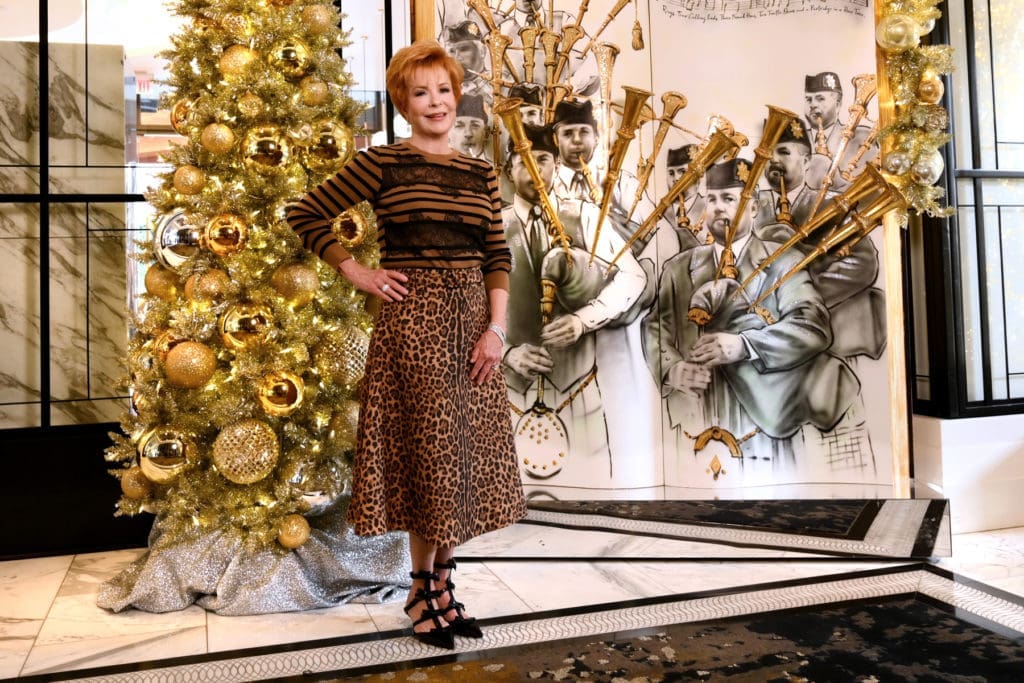 Jo Ann Petersen, Trees of Hope Underwriting Chair, wears Valentino sweater, skirt, and shoes from Tootsies. (Photo by Al Torres Photography)