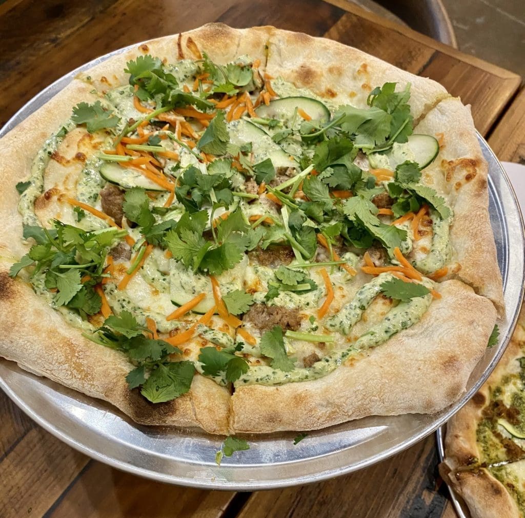 The banh mi pizza at Neony Pizza Works is a lemongrass sausage, cucumber, pickled carrot, mozzarella, and cilantro aioli dream. (Photo by Megan Ziots) 
