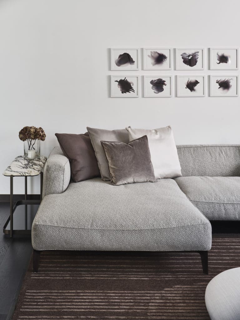 Giorgetti sofa, sidetable and area rug paired with John David Robbins "Smokes 1-12" series artwork.