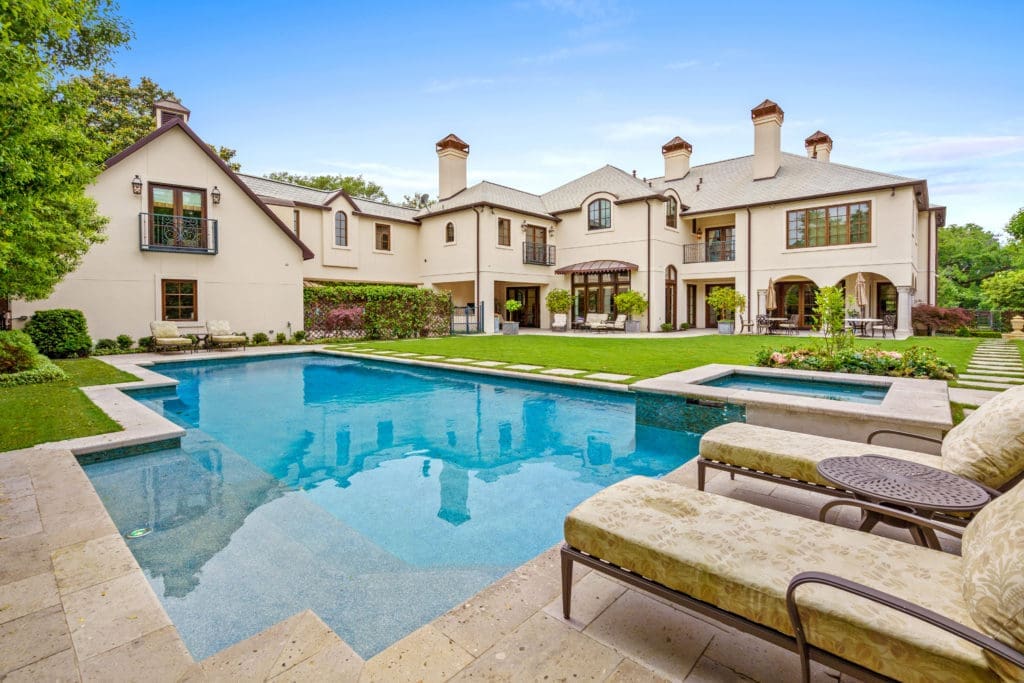 The outdoor experience of this home includes an oasis in the backyard with a tree-lined pool.