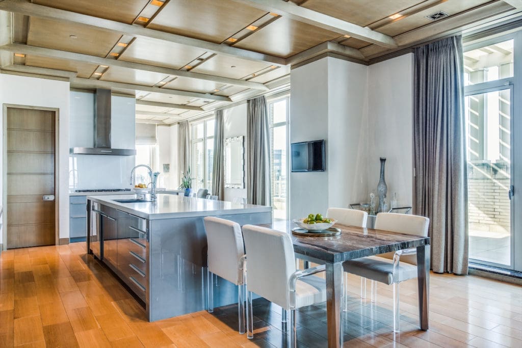 A well-placed TV lets you  catch up on your shows while you cook. (Photo by Shoot2Sell for Douglas Elliman)