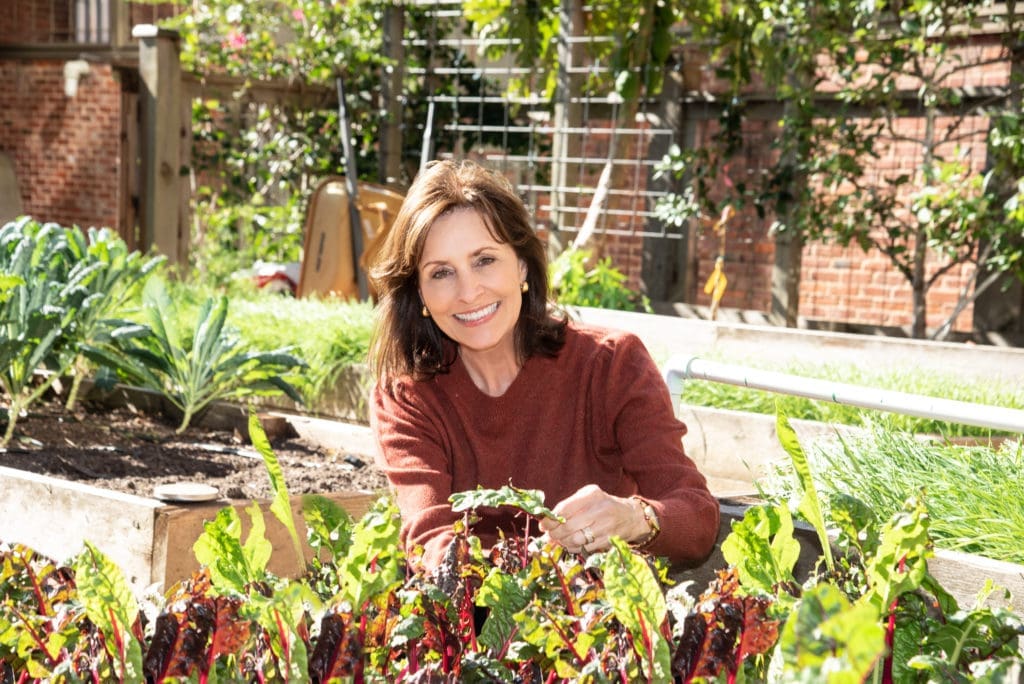 Laura S. Moore in the holistic garden that feeds UTHealth School of Public Health's Nourish Program, the source of Moore's book How Good Food Works From Seed to Table. (Photo by Alexander's Fine Portrait Design)