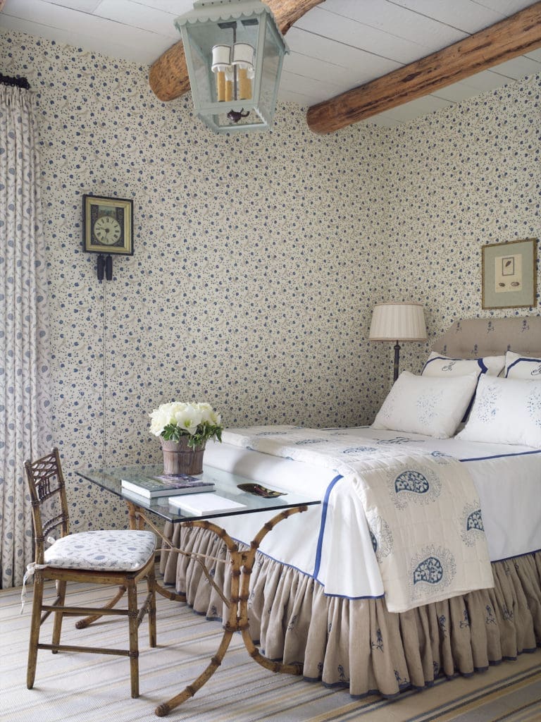 A bedroom with mixed patterns including Pierre Frey wallpaper and Bennison fabric upholstery.  (Photo by Tria Giovan)