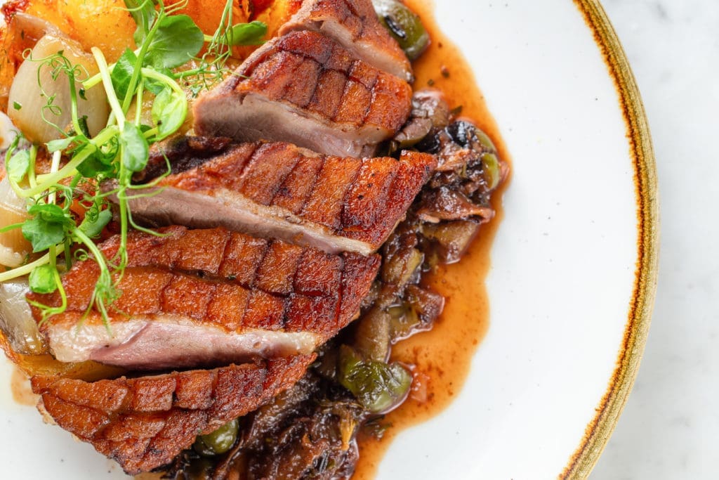 Roasted duck breast with grapes and olives roasted in port, duck fat potato, shallot confit is new on the Brasserie 19 menu. (Photo by Andrew Hemmingway)