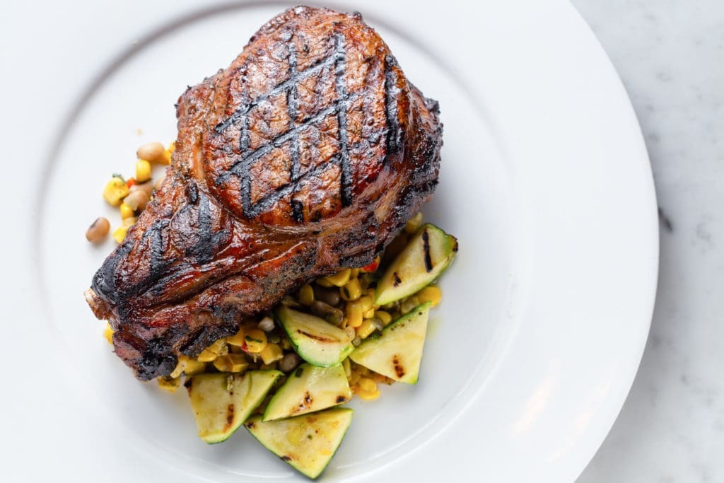 New to the Brasserie 19 menu is the Sakura pork chop with sumac glaze, roasted corn succotash, purslane, squash. (Photo by Andrew Hemmingway)