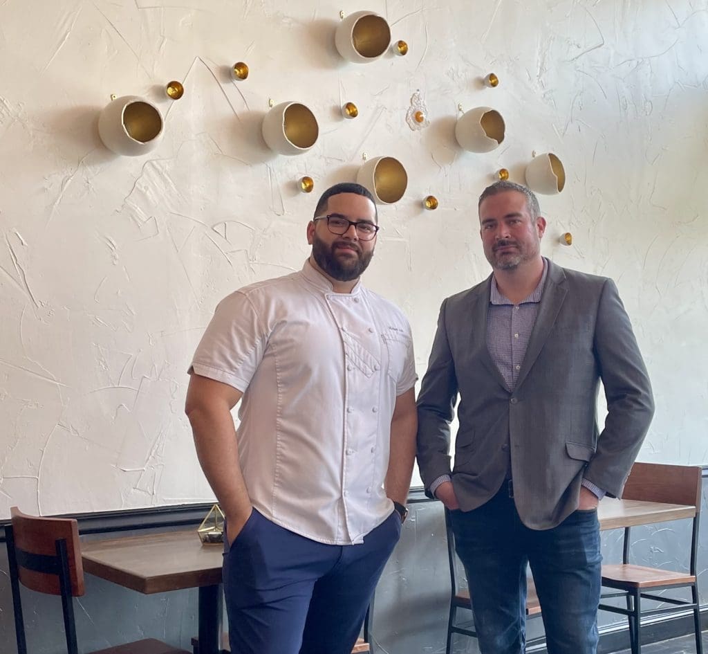 Chef Michael Arlt and business partner Dustin Lee in front of their broken egg artwork. Photo by Courtney Dabney.