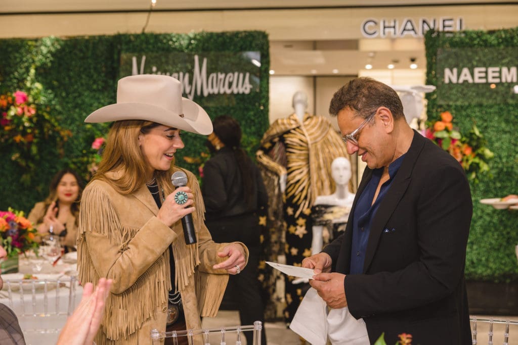 Kristina Somerville presents Naeem Khan with front row tickets to the 2022 Houston Livestock Show and Rodeo.  (Photo by Johnny Than)