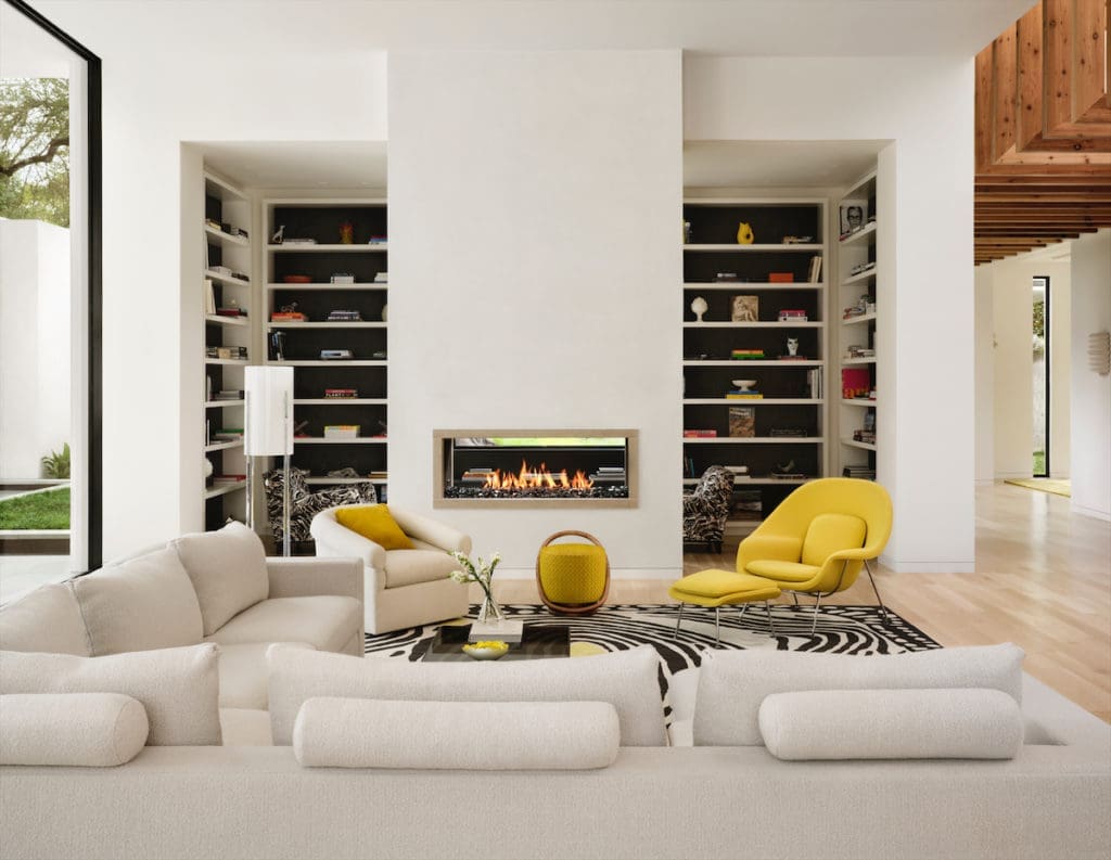 The family room's sectional sofa is designed by Julie Hayes, who also designed the rug based on a vintage one seen at a Paris flea market. Womb chair and ottoman Eero Saarinen for Knoll and Porada poof, all from Scott + Cooner. (Photo by Lisa Petrole)