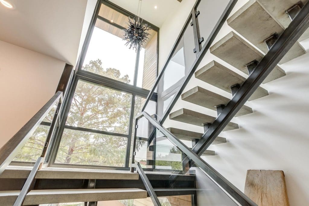 Main staircase with concrete treads, awash in sunlight.