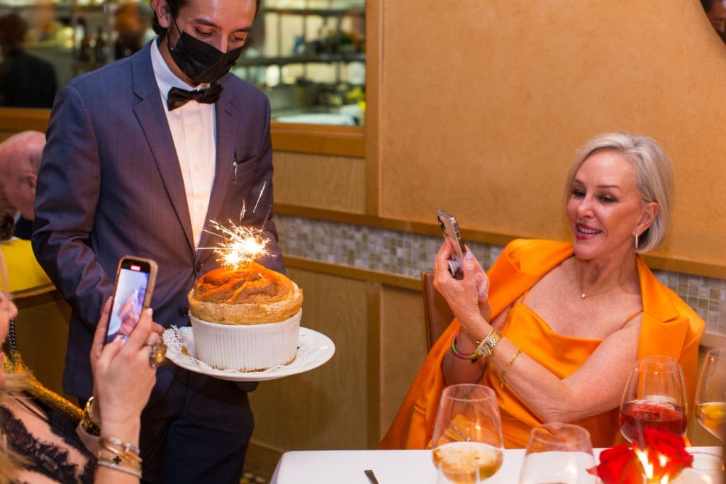 Sheree Frede snaps a photo of her soufflé dessert at the Tony's Day in Houston dinner celebration (Photo by Andrew Hemingway)