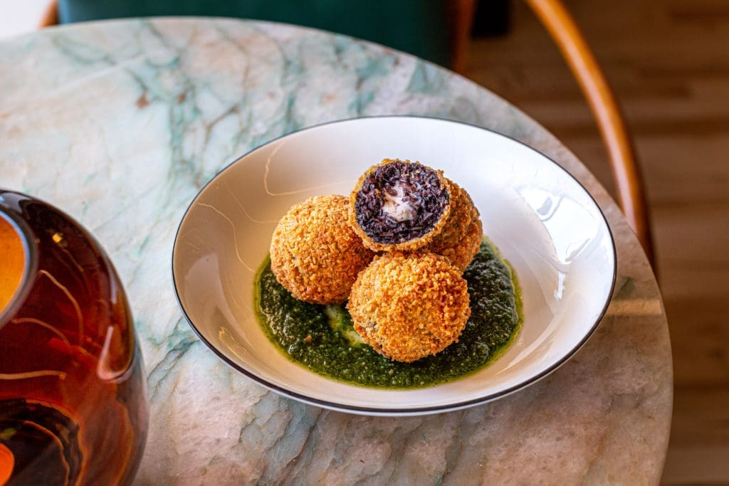 Indulge in warm black rice arancini filled with oozing cheese at the intimate 1,000 square foot new wine bar dubbed Lees Den. (Photo by Jenn Duncan)