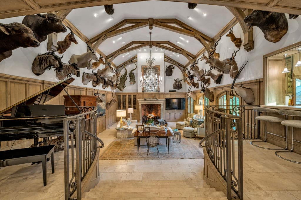 Architectural beams top the great room lined with safari trophies.