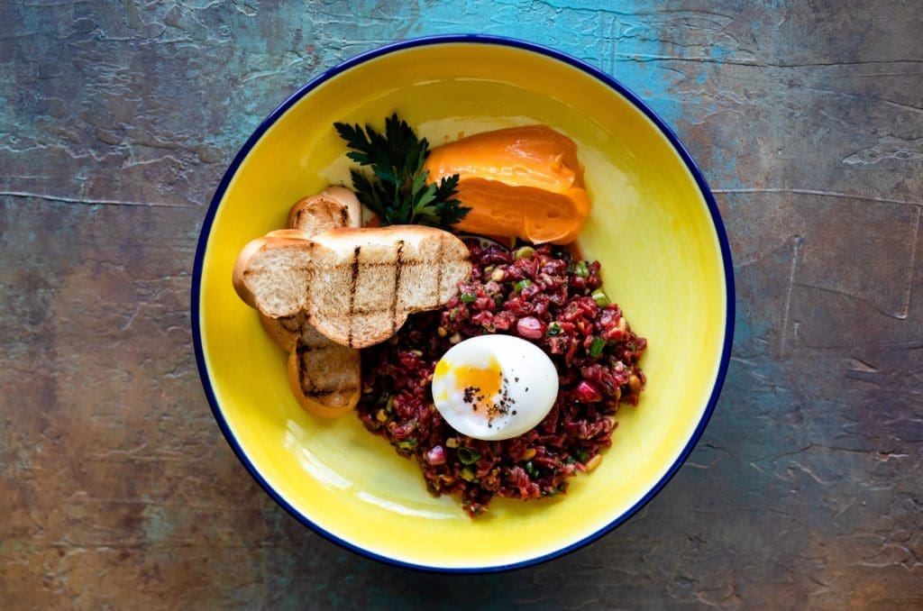 Beef Tartare is served at Hamsa with a soft boiled egg with a Shata aioli and toasted challah.  (Photo by Kirsten Gilliam)