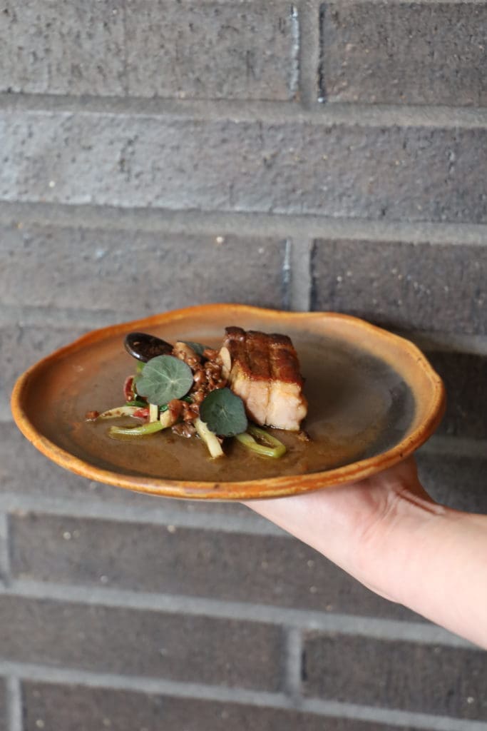 This hot dish at Uchiko is made with a post oak grilled Iberico pork belly and is served with charred cabbage and topped with a walnut, tamarind, burnt honey and chili glaze. (Courtesy of Hai Hospitality) 