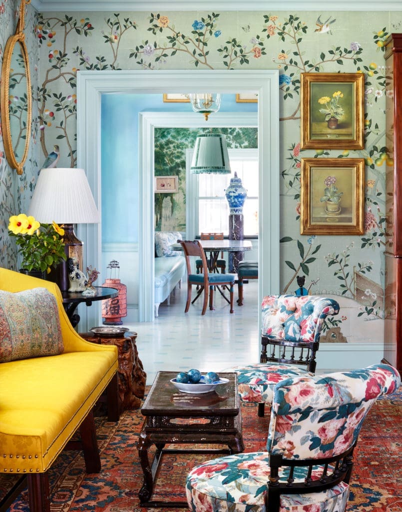 A charming seating area in the dining room includes an antique sofa. The pair of slipper chairs, upholstered in Jasper fabric, once belonged to Robert Denning and Vincent Fourcade. Walls are papered in de Gournay. (Photo by Trevor Tondro and Otto )