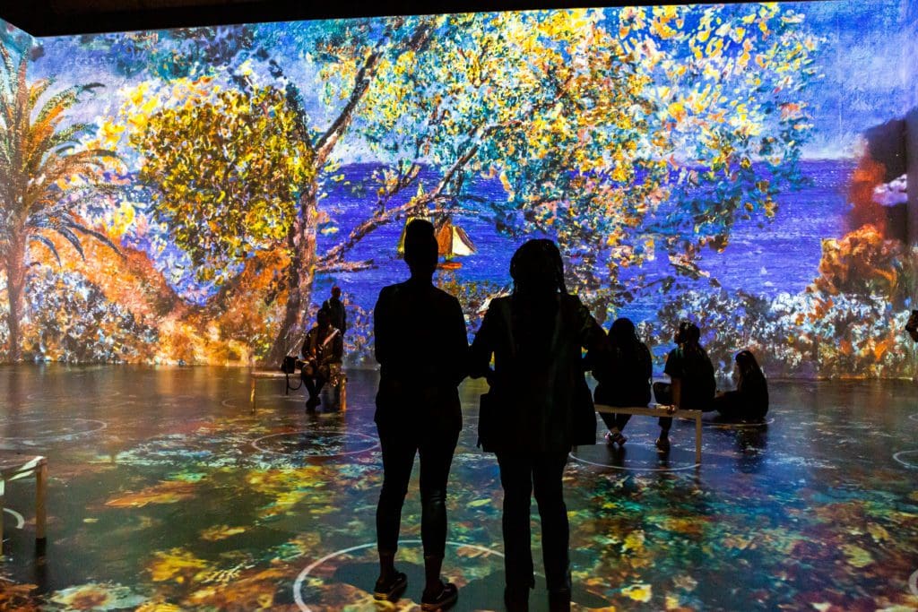 The cavernous exhibit room at "Immersive Monet & The Impressionists" is filled with vibrant colors. (Photo by Patrick Hodgon)