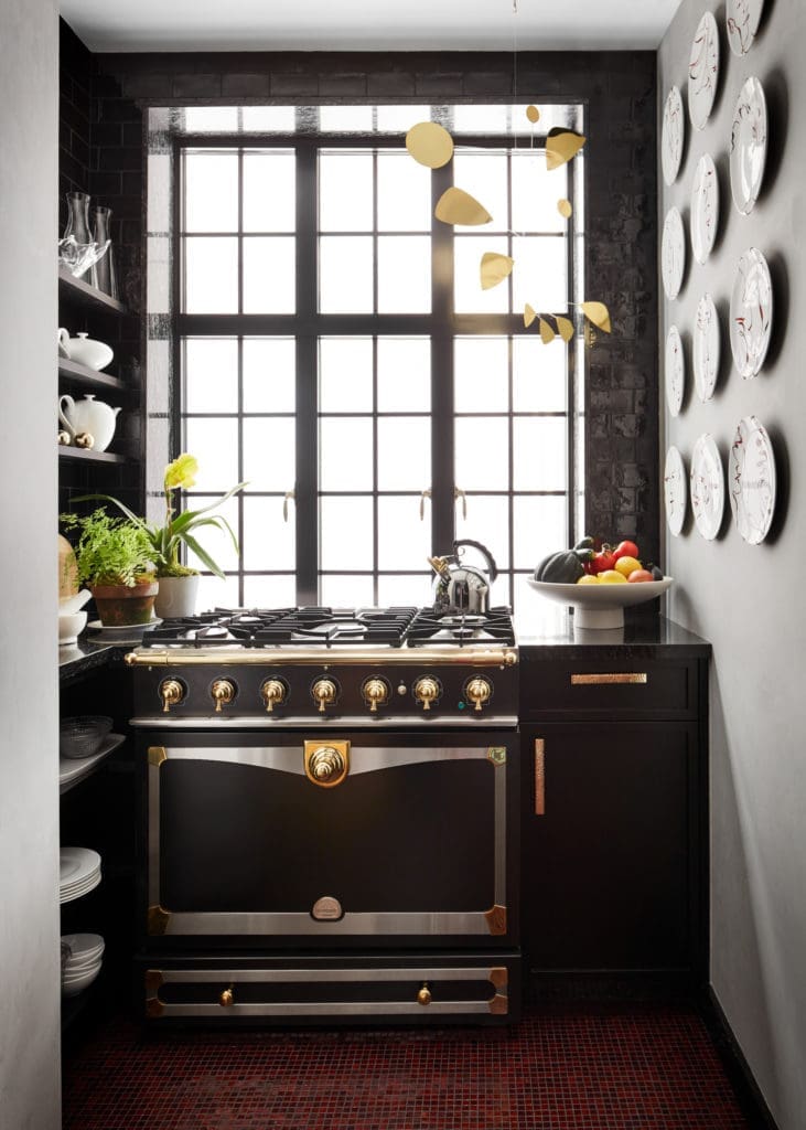  In Caleb Anderson’s New York apartment, the kitchen is a wonderful room in which to cook when time permits. A little garden grows to the left; to the right, a series of plates hand-painted with abstract faces animates the wall. The mobile might be impractical, but it inserts a playful note. (Photo by Stephen Kent Johnson)