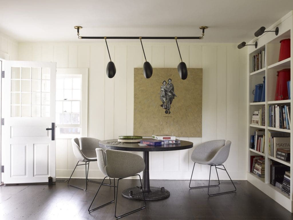 Stephen Sills wanted to give a modern feel to the original architecture of this 18th-century New England saltbox cottage, which is painted white with restored beams, fireplace, and floors. The furniture is painted white or stained dark black with modern upholstery. (Photo by William Waldron)